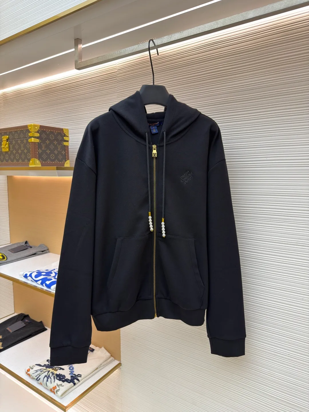 LOUIS VUITTON Pearl Pendant Zipper Jacket ●Original version: Purchased and developed for 10999 ●Item number: 1682253-B60 ●Fabric: wool blended fabric ●Technology: knitted embroidery production ●Color: black ●Version: fitted version ●Weight: about 715 grams ●Size: S-M-L-XL ●Description: This Louis Vuitton black hooded zipper sweatshirt is made of high-weight pure cotton waffle fabric. The fabric has been combed and singed, with a uniform and fine surface texture. It is also treated with anti-pilling and pre-shrunk, making it soft to the touch and not easily deformed after long-term wear. The brand logo on the left side of the body adopts the same color dark pattern embossing process and is hot-pressed through a temperature-controlled mold. The pattern is low-key and has a strong three-dimensional effect. The drawstring is embellished with custom-made pearl decorations, which are fixed by hand-beading. The surface of the pearls is polished to have a good luster and will not fall off easily. The metal zipper is made of gold-plated brass and has been treated with antioxidant treatment. The chain head is engraved with the brand's classic logo, making it smooth and wear-resistant. The ribs on the cuffs and hem are made of spandex blended material, which has excellent resilience and is not easy to loosen. The overall design is cut with loose shoulders, combined with double-needle hemming and seamless splicing technology. The stitching is fine and flat, which not only ensures comfort, but also shows the exquisite craftsmanship and brand texture of high-end garments. The overall wiring is straight and delicate, the fabric is comfortable and soft, and the color is consistent without color difference. It can be matched with the same style to create a fashionable look and control various occasions. Customized accessories, complete with three standards, same style for men and women!